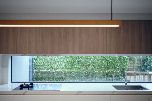 Contempory Kitchen With Clear Window Splashback And Timber Doors