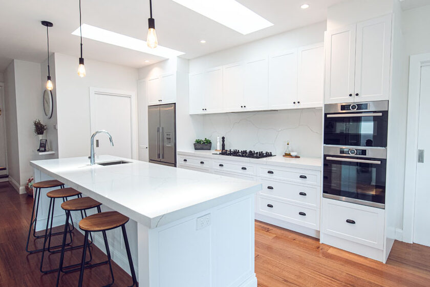 Hamptons style white kitchen with shaker cabinetry, large island and timber flooring